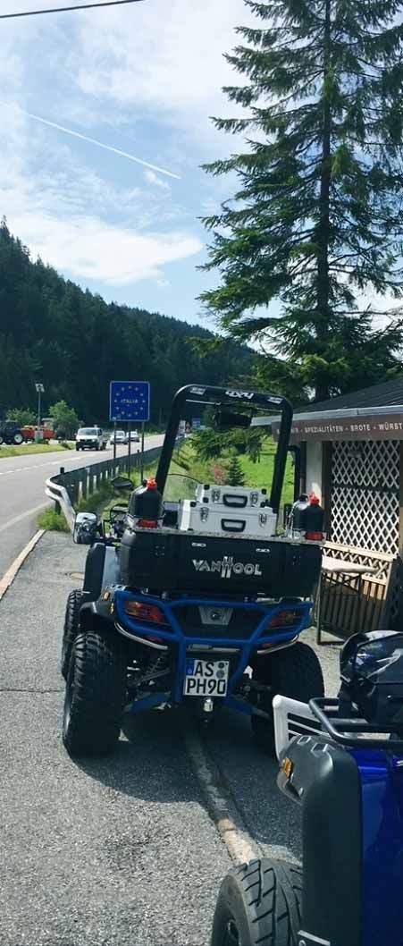 Am Straßenrand parkt ein blaues Geländefahrzeug.