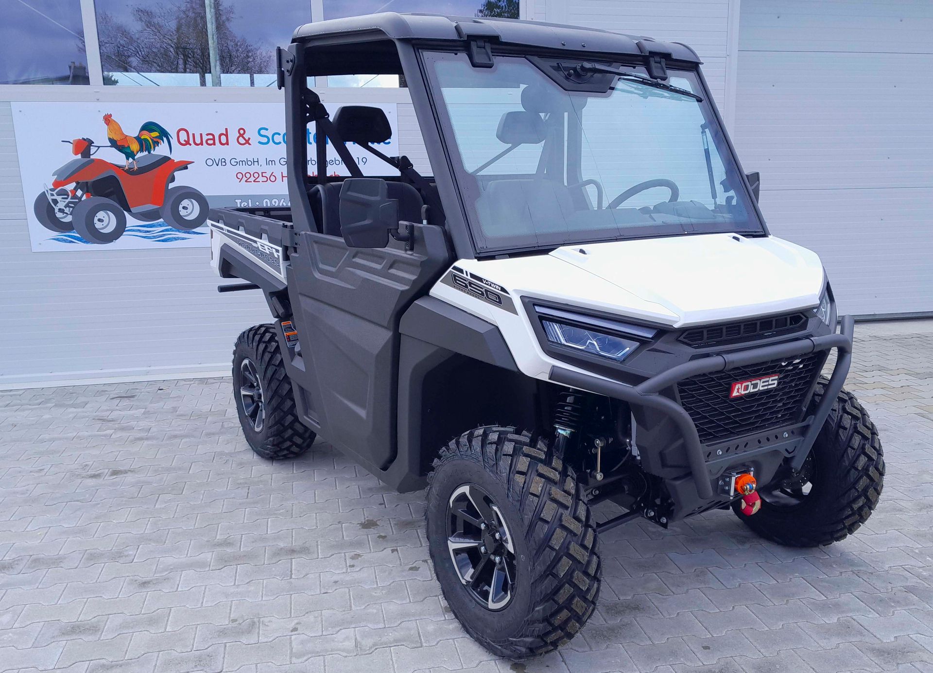 Ein schwarz-weißes Geländefahrzeug ist vor einem Gebäude geparkt.