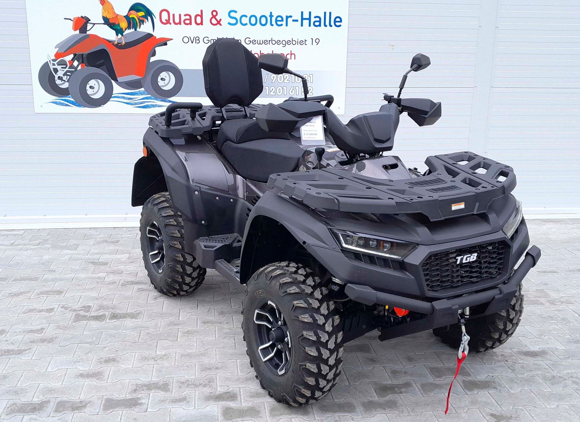 Ein schwarzes ATV parkt vor einem Schild mit der Aufschrift „Quad & Scooter-Halle“.