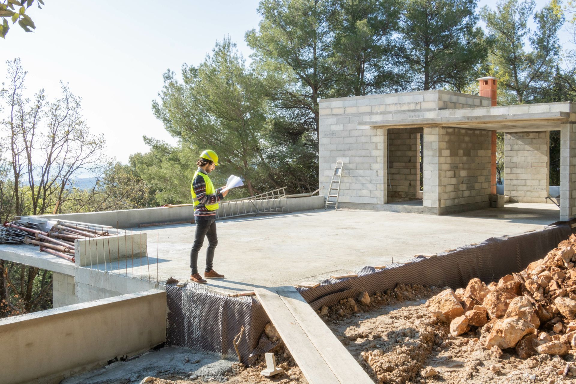 Architecte avec des plans sur un site de maison en construction