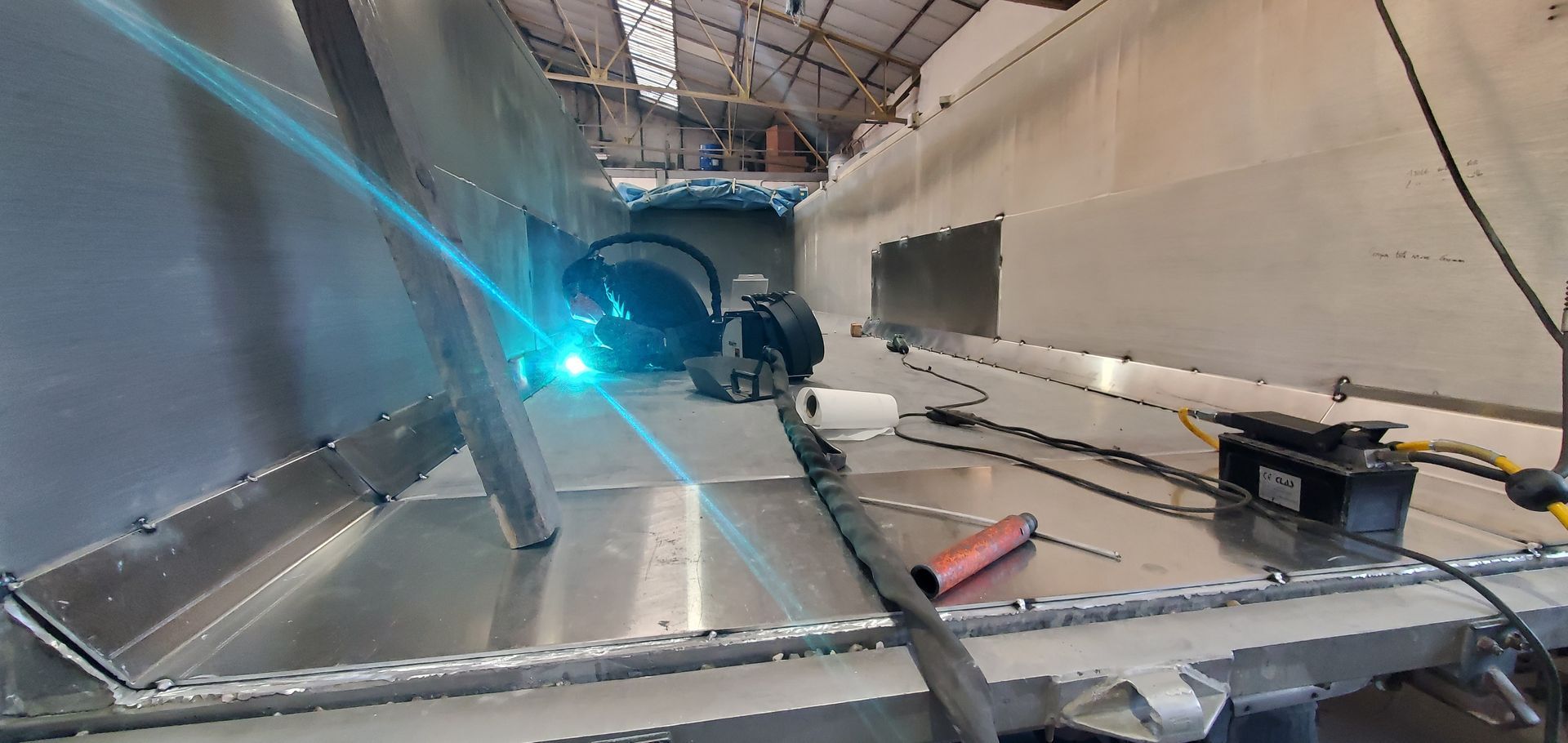 Un monsieur soude le haut d'un camion benne en aluminium