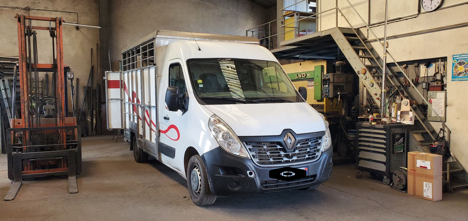 Camionnette de livraison blanche à l'intérieur d'un atelier de réparation, pour changement de plancher en resine 