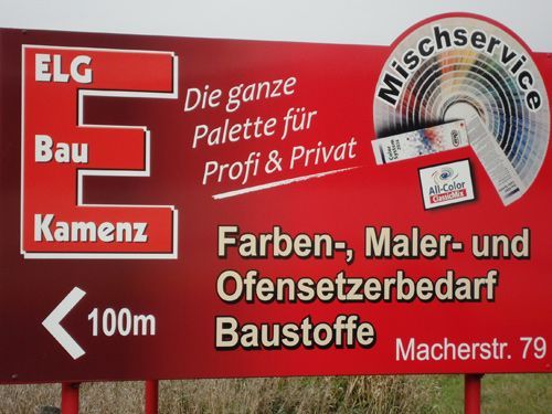 Schild für ELG Bau Kamenz, Werbung für Farbe, Zubehör und Service. Rot, weißer Text und Logo, Richtungspfeil.