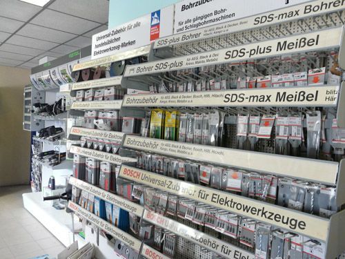 Regale mit Bohrern und Meißeln in einem Baumarkt. Zu sehen sind Produkte mit der Aufschrift „SDS-max“ und „SDS-plus“.