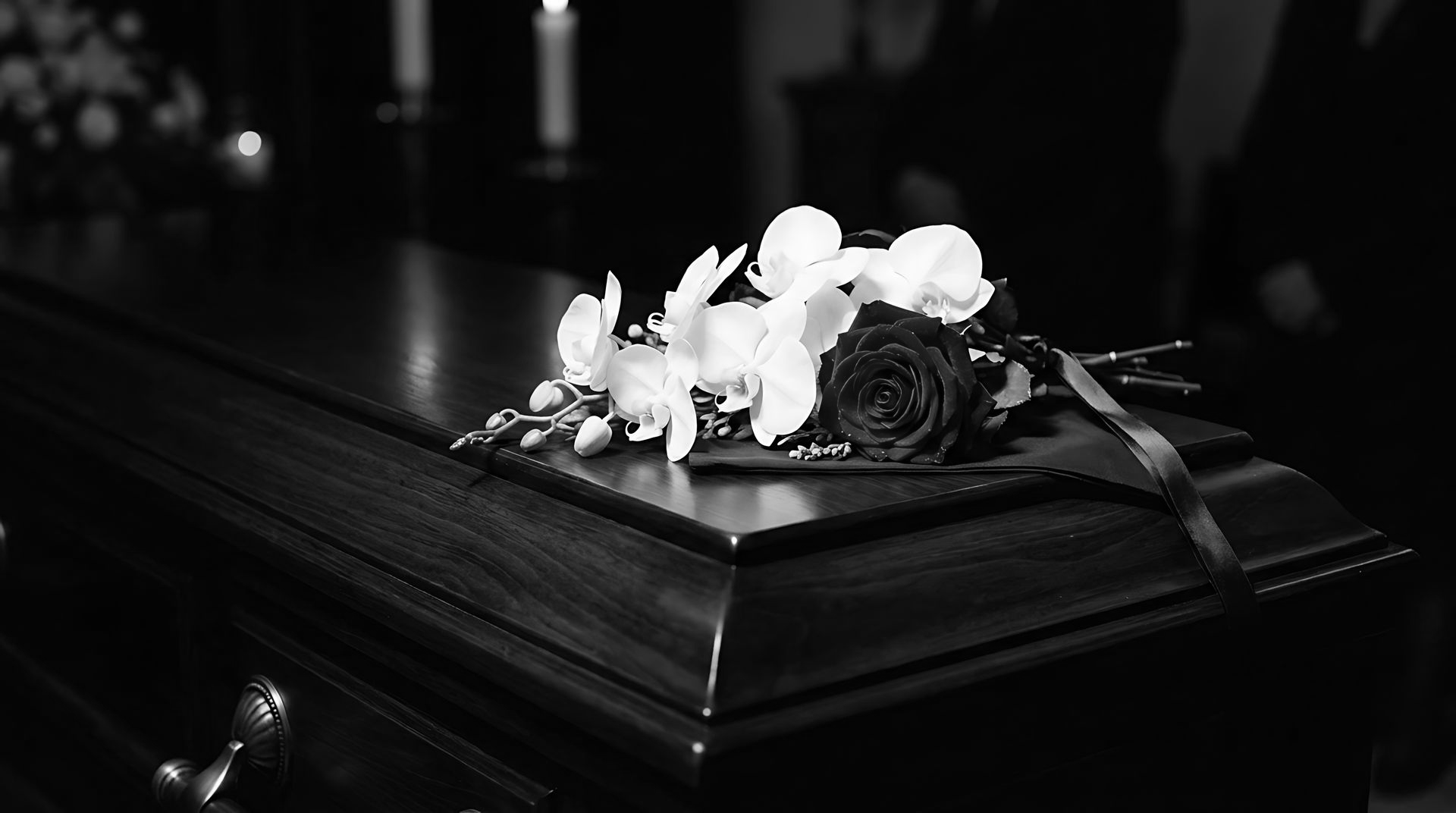 Des fleurs blanches sur un cercueil sombre dans un cadre funéraire tamisé