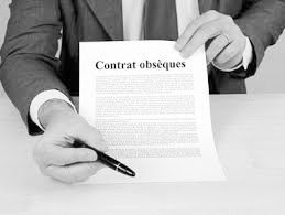 Une personne signant un contrat d'obsèques français sur un bureau avec un stylo