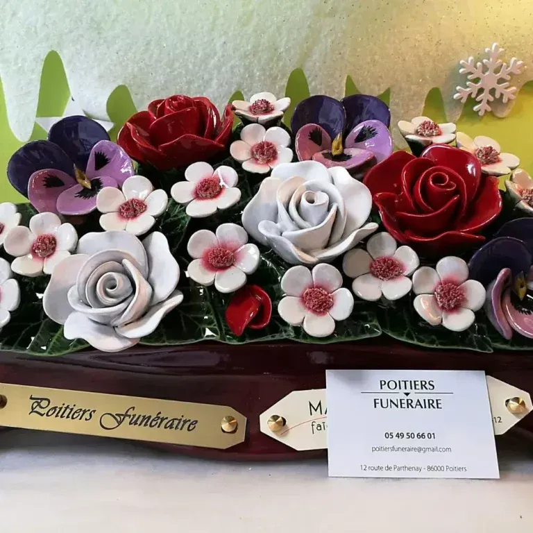 Composition florale colorée avec des fleurs rouges, blanches et violettes dans une boîte décorative avec étiquettes