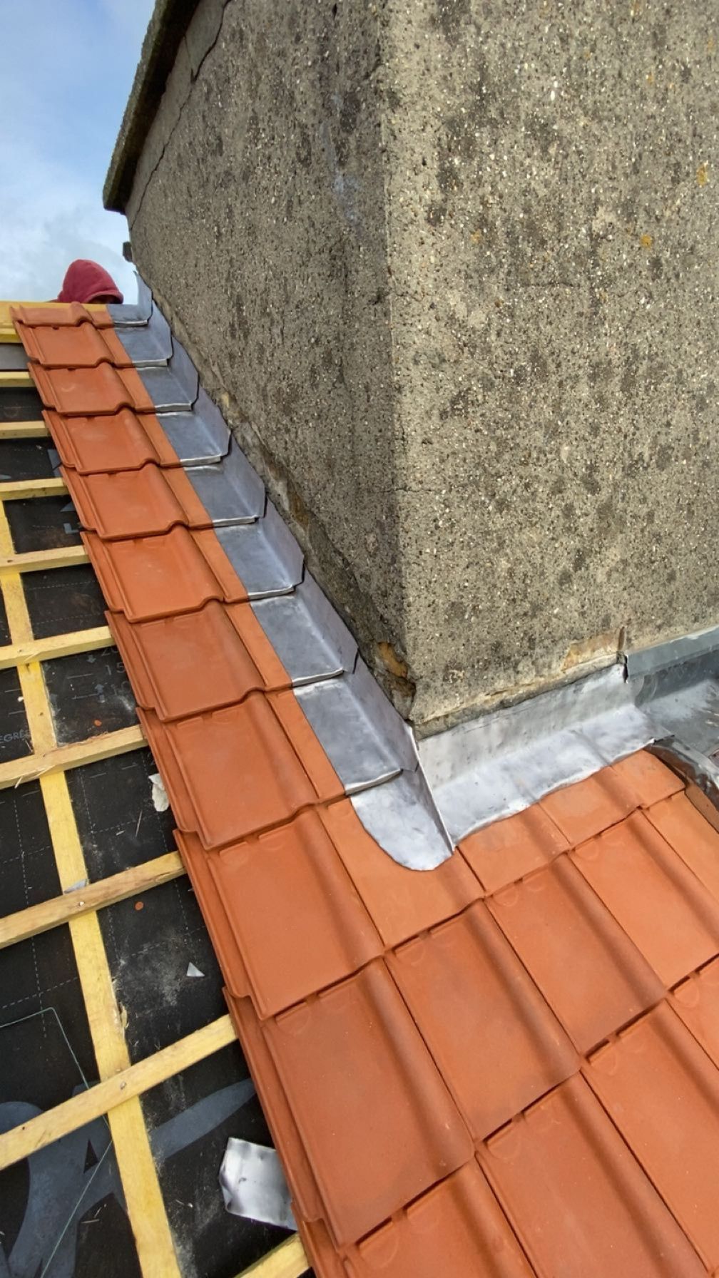 Tuiles de toit et solins en plomb autour d'une cheminée.