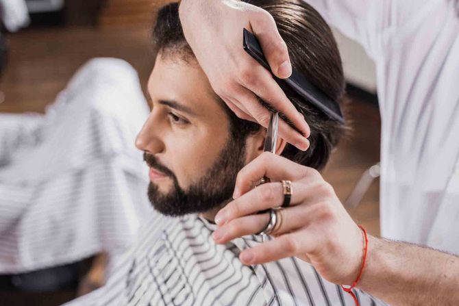 Mujer con cabello castaño largo en un salón, de espaldas a la cámara. Cabello liso y de corte recto.