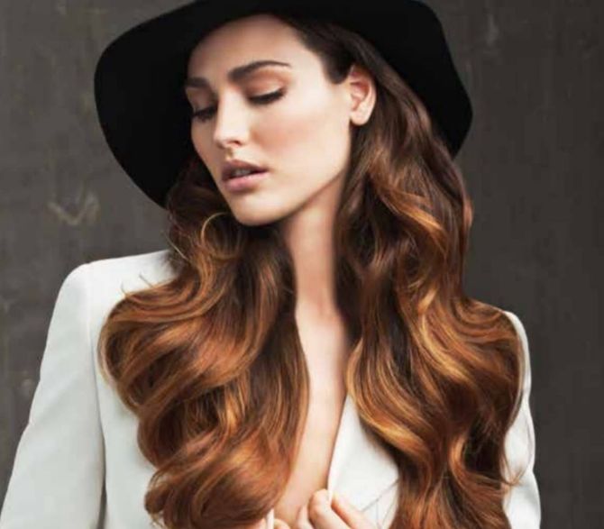 Mujer con un corte bob corto y castaño, vista de espaldas en una peluquería. Lleva una blusa estampada.
