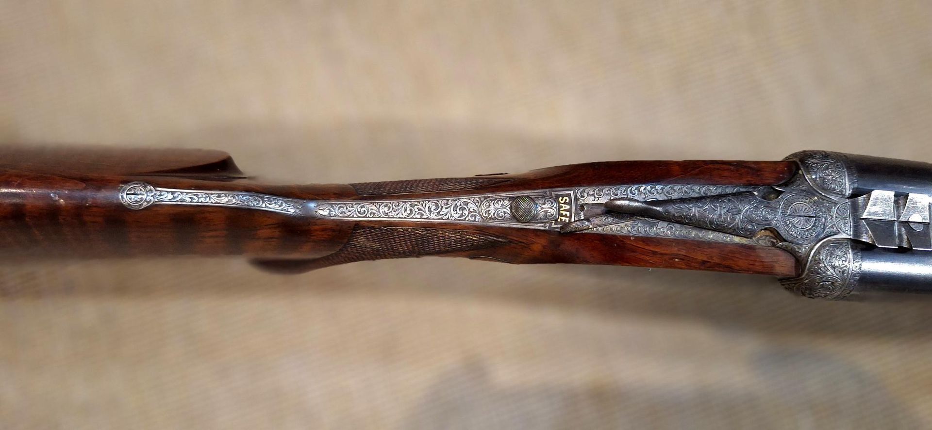 Primer plano de un objeto de madera marrón con un extremo agrietado y rematado con metal.