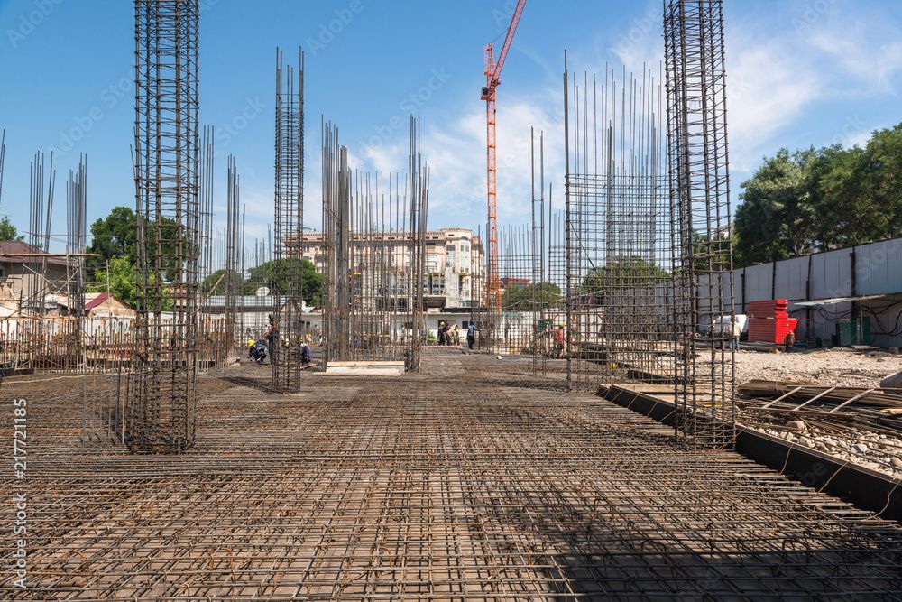 Baustelle mit Stahlgerüst; Kran im Hintergrund, klarer Himmel.