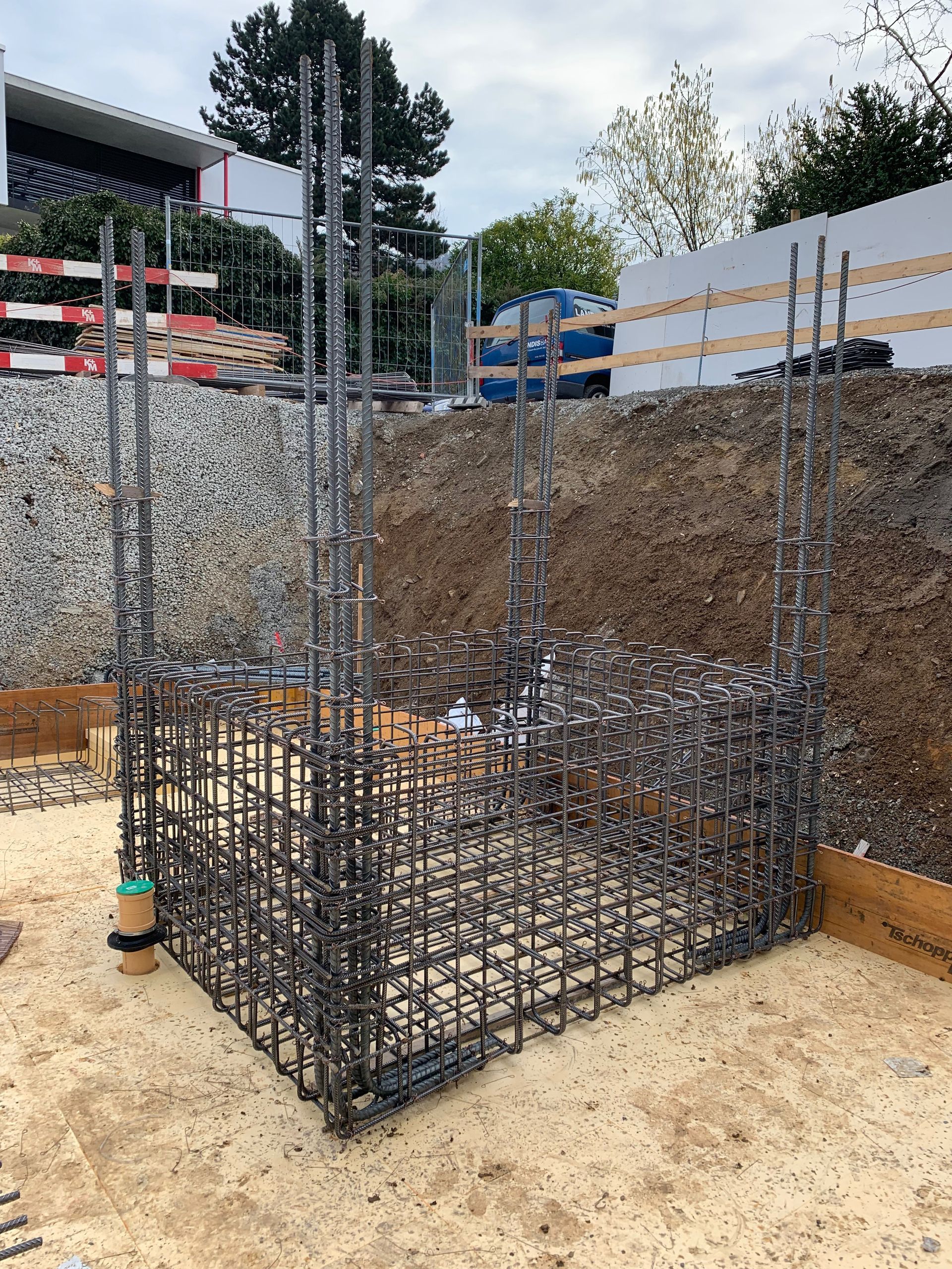 Baustelle mit einem Stahlbewehrungskorb für ein Gebäudefundament.