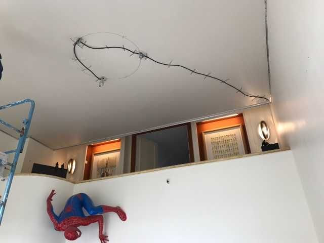 Décoration Spider-Man sur un mur blanc dans une pièce avec mezzanine et fil de suspension.
