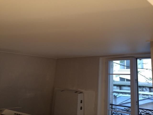 Pièce beige vide avec une fenêtre et un radiateur blanc près du coin