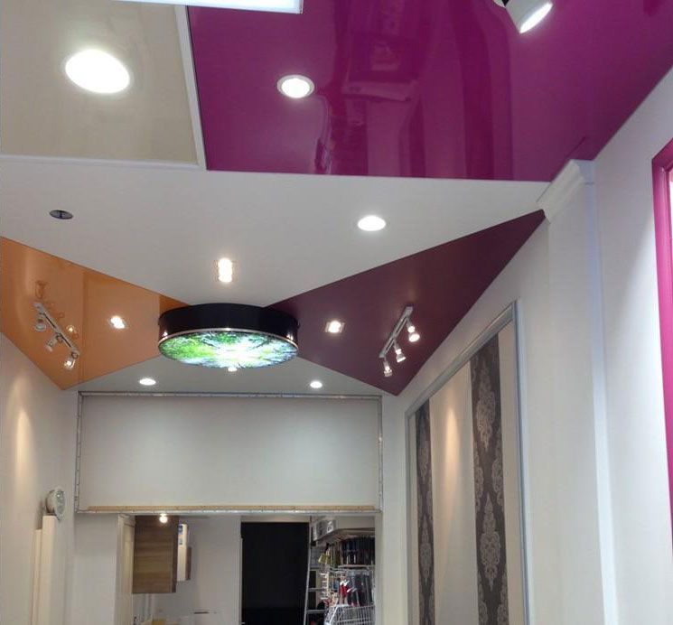 Couloir intérieur moderne avec panneaux de plafond géométriques colorés et éclairage encastré