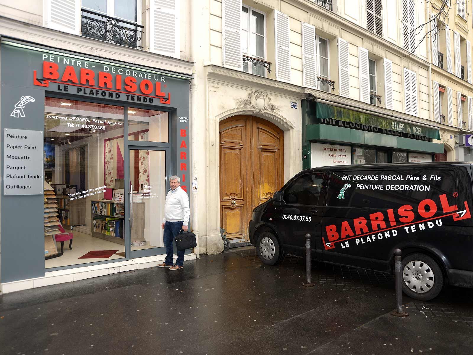 Façade du magasin BARRISOL près d'une camionnette noire dans une rue pluvieuse de la ville