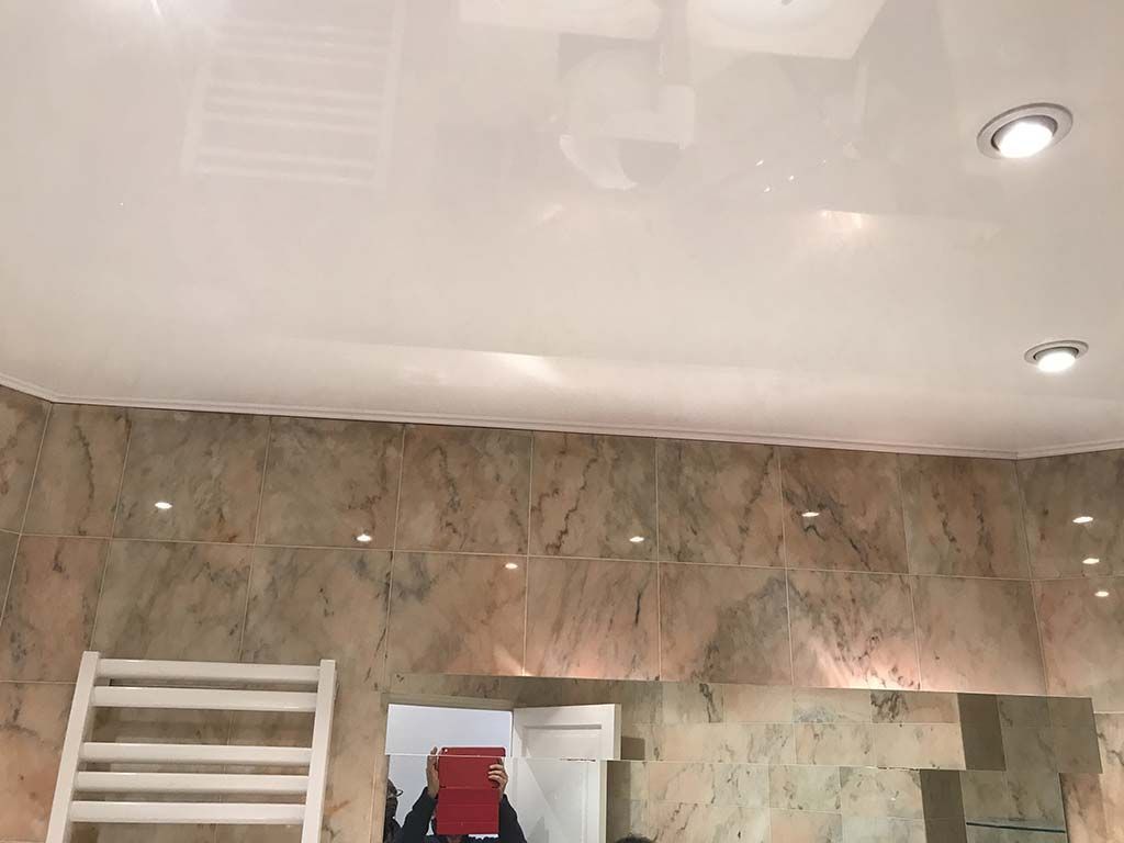 Pièce aux murs de marbre avec échelle, petite armoire rouge et spots encastrés au plafond