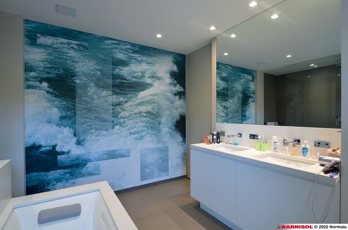 Salle de bains moderne avec fresque murale représentant l'océan, meuble-lavabo blanc, miroir et baignoire.