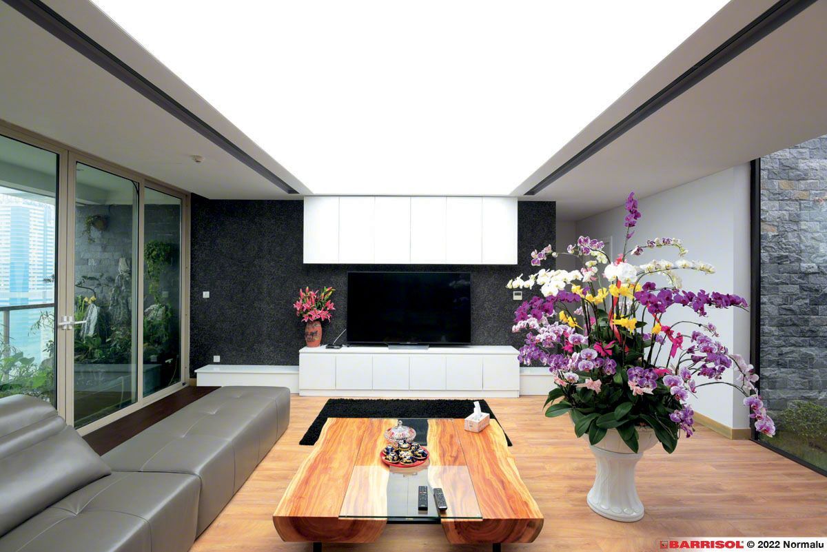 Salon moderne avec canapé gris, table basse en bois et grande composition florale près des portes coulissantes en verre
