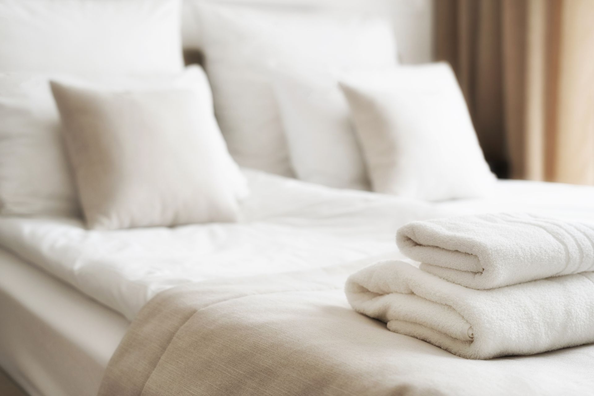 Lit blanc avec des serviettes soigneusement pliées dans une chambre d'hôtel.