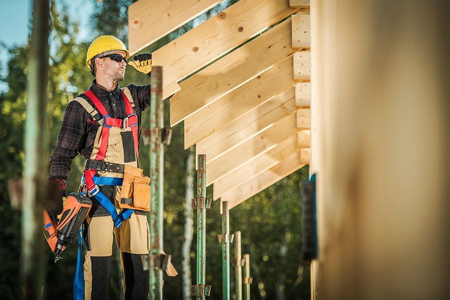 Un ouvrier du bâtiment travaille sur une structure en bois.