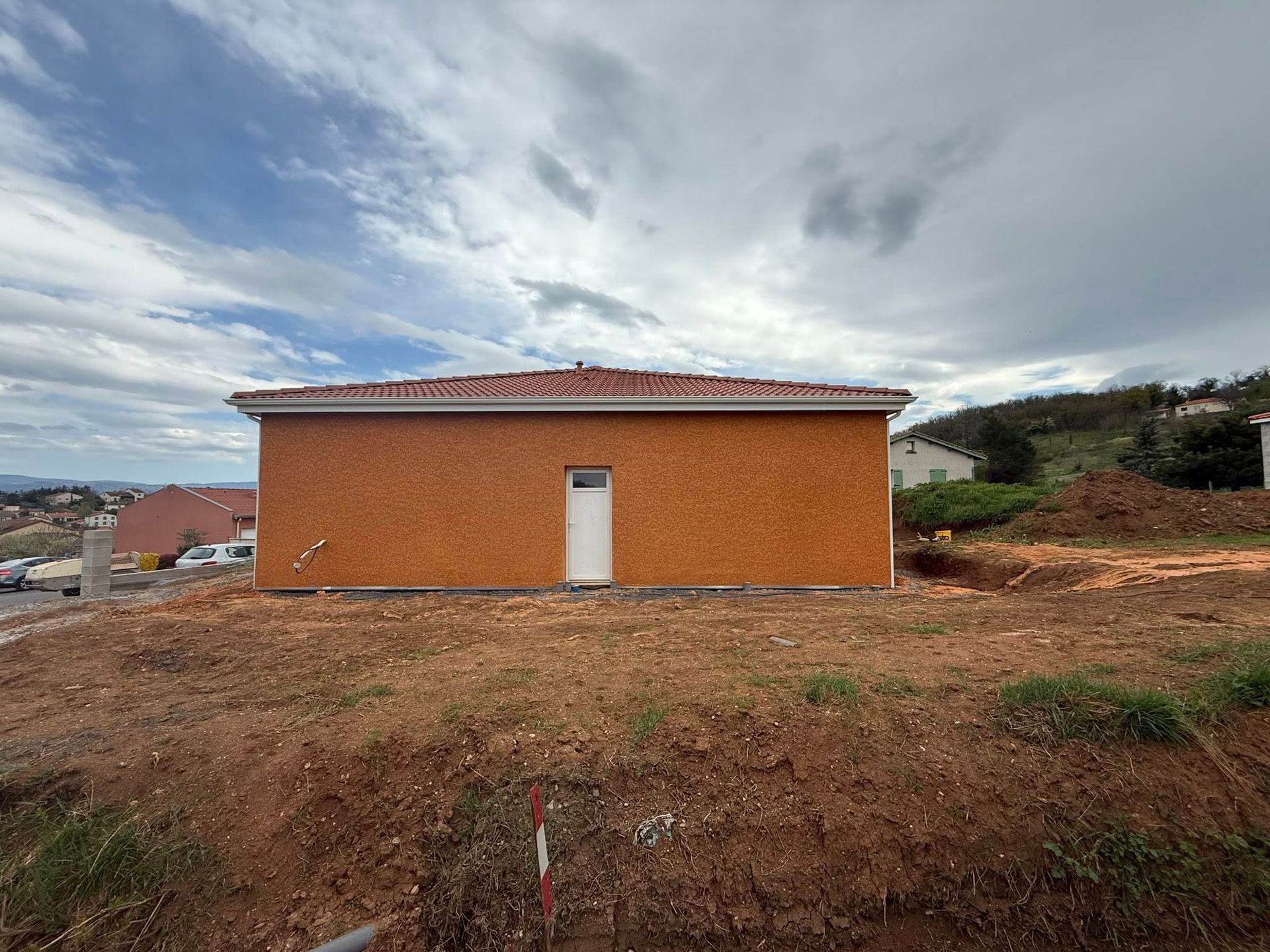 Une maison orange avec une porte blanche.