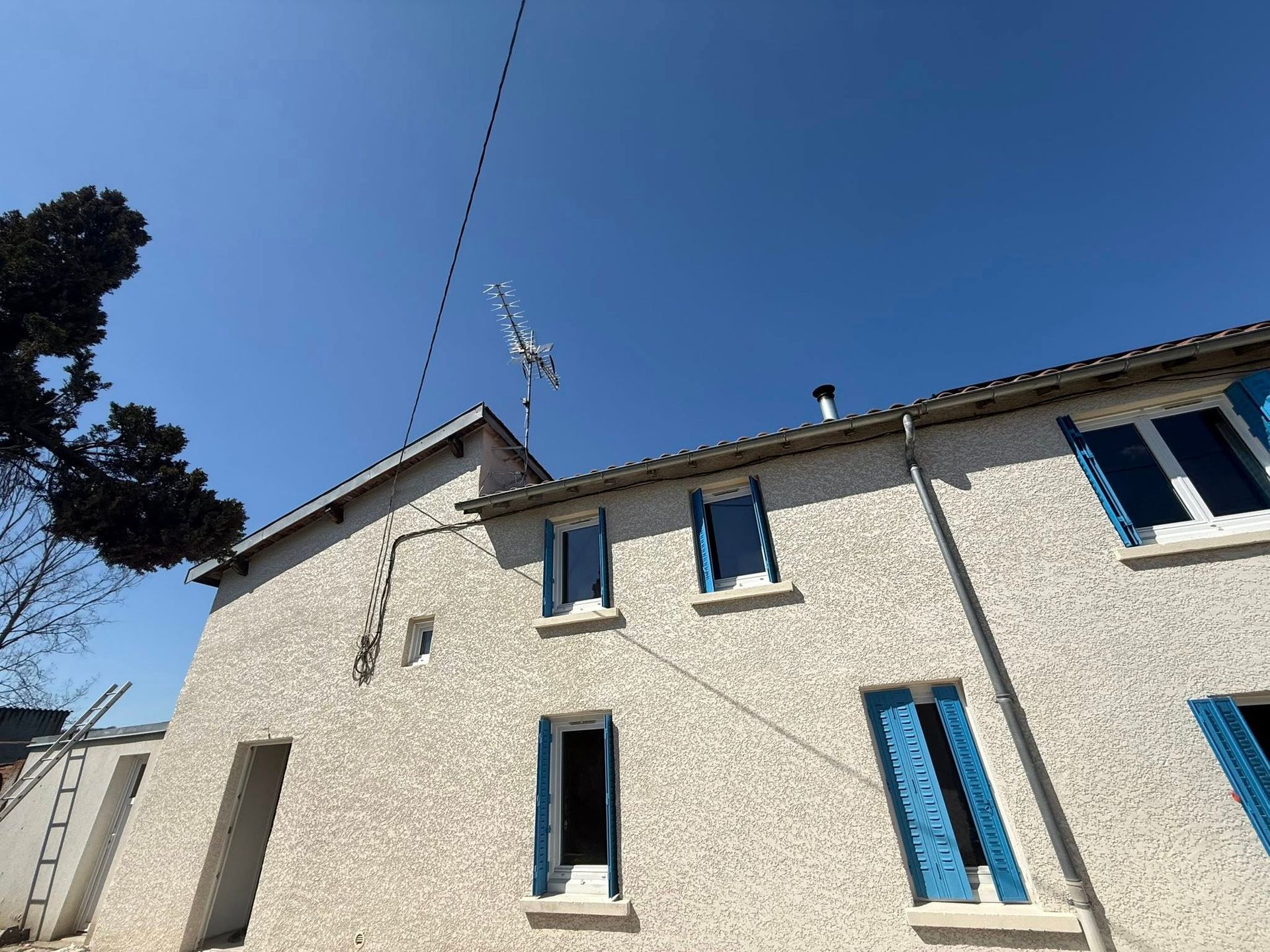 Une maison avec des volets bleus.