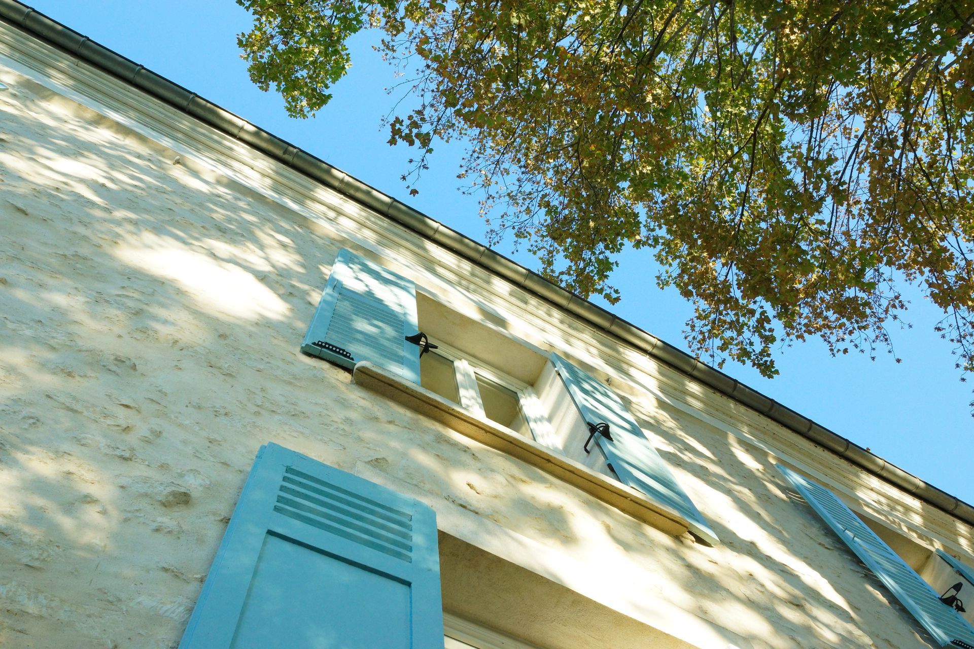Une maison avec des volets bleu clair.