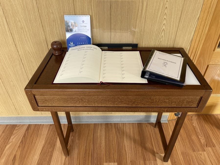 Una mesa de madera con un libro y carpetas encima.