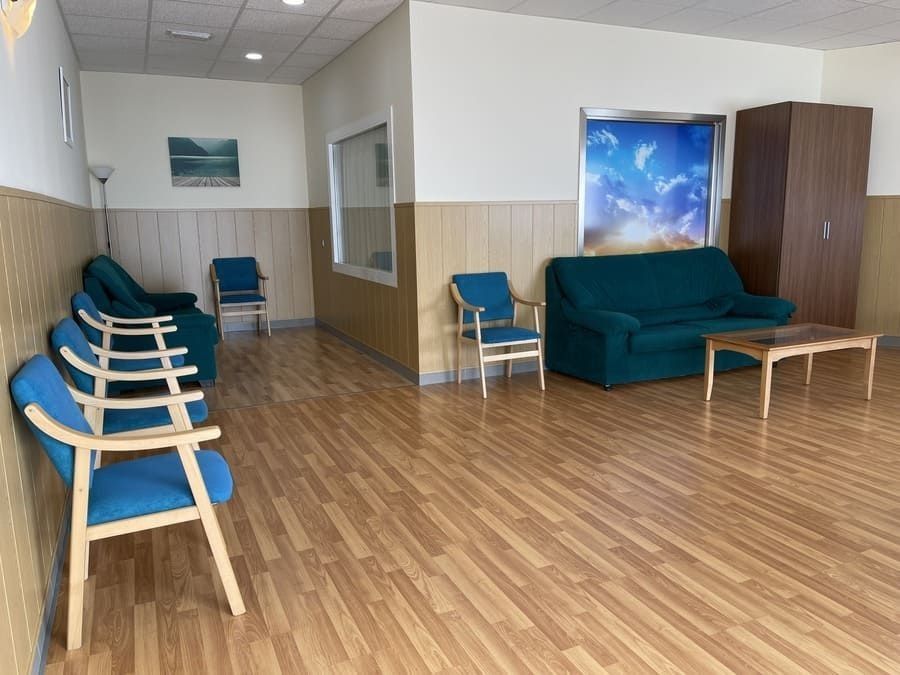 Una sala de estar con un sofá, sillas y una mesa.