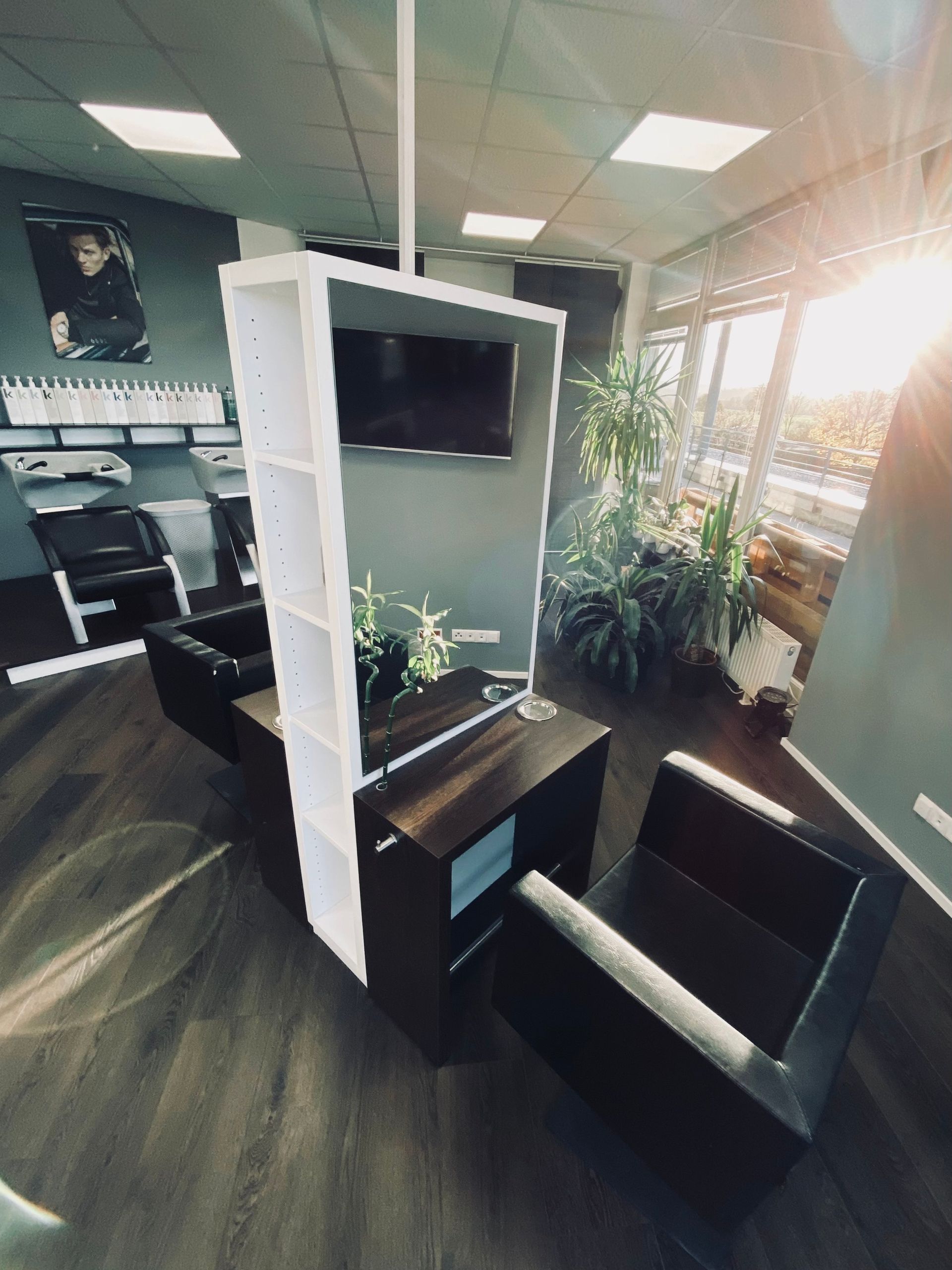 Ein Salon mit Stühlen und einem Fernseher an der Wand