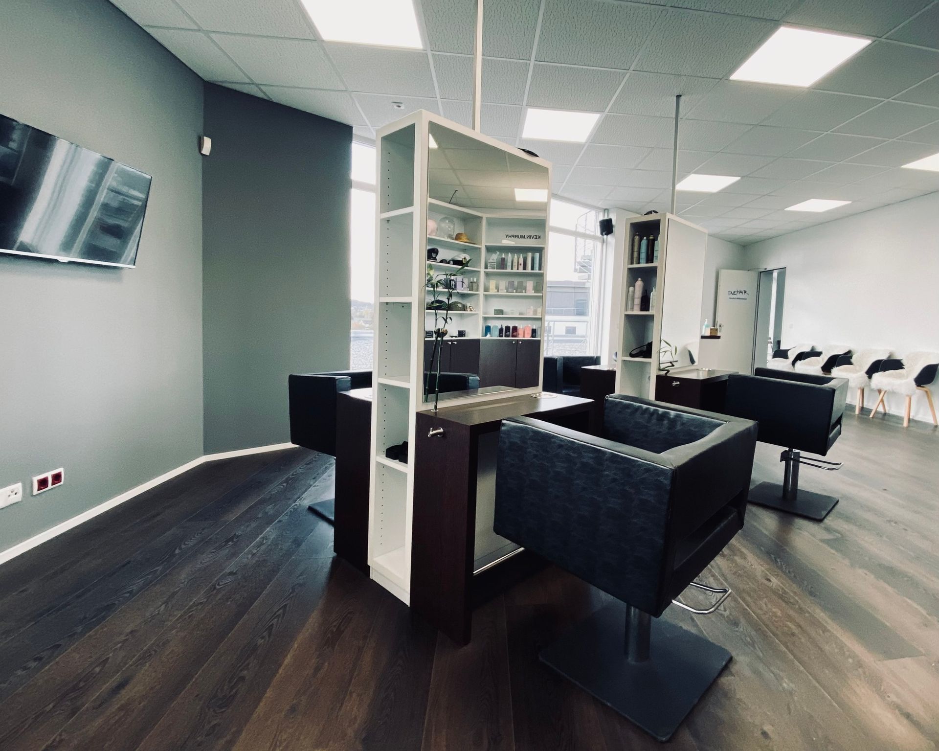 Ein Salon mit vielen Stühlen und Regalen