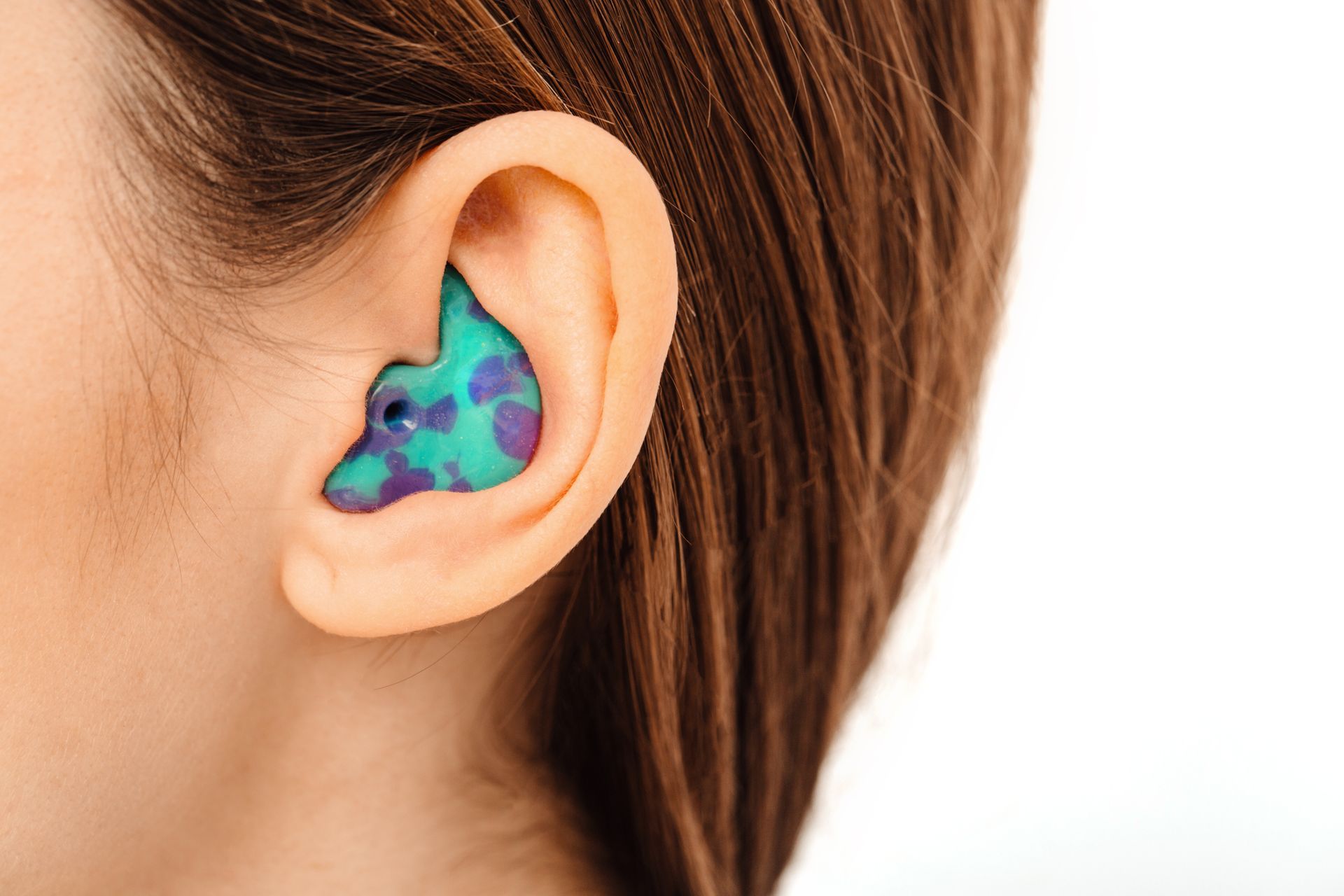 Gros plan sur une oreille avec un appareil auditif ou un embout auriculaire.