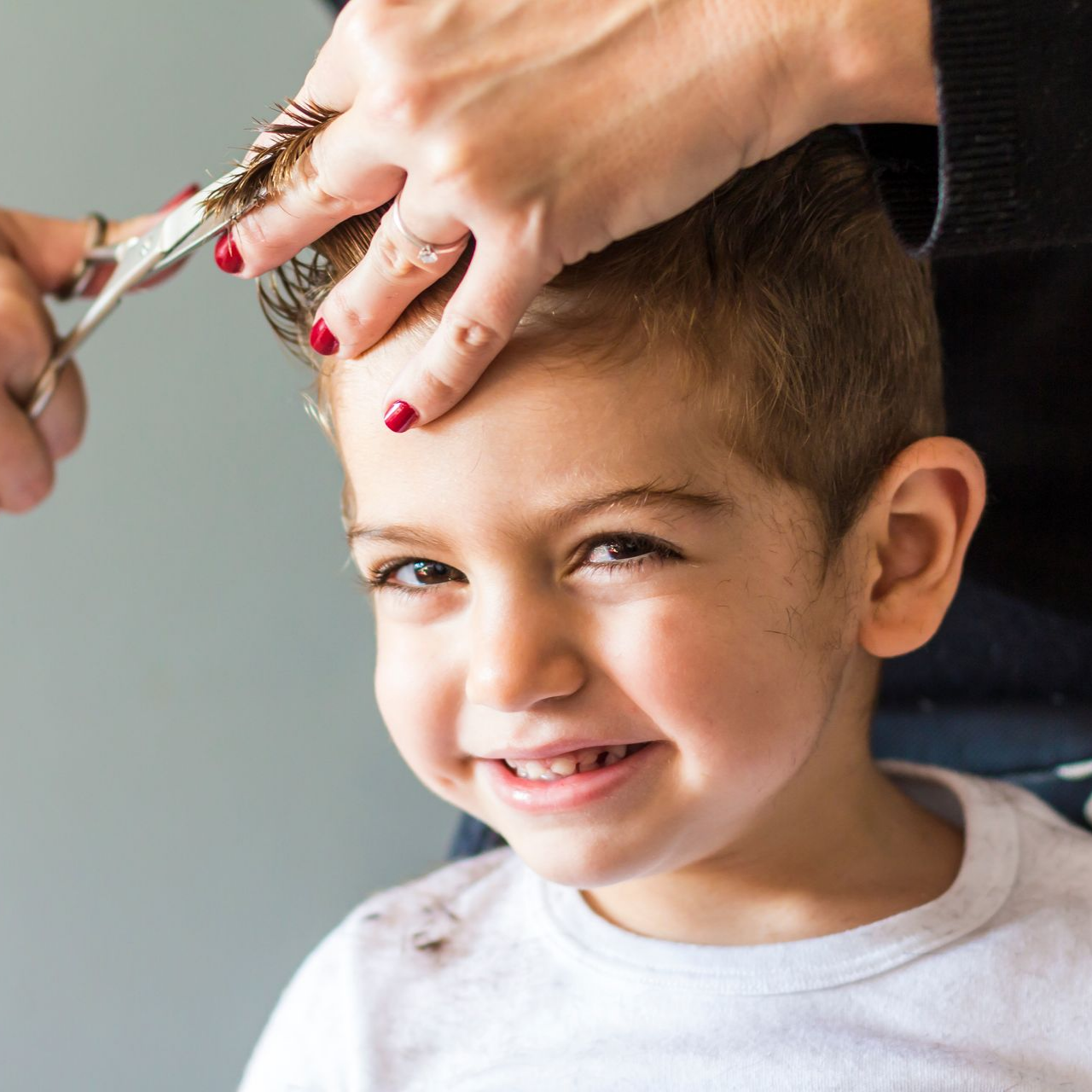 Un enfant souriant se fait couper les cheveux