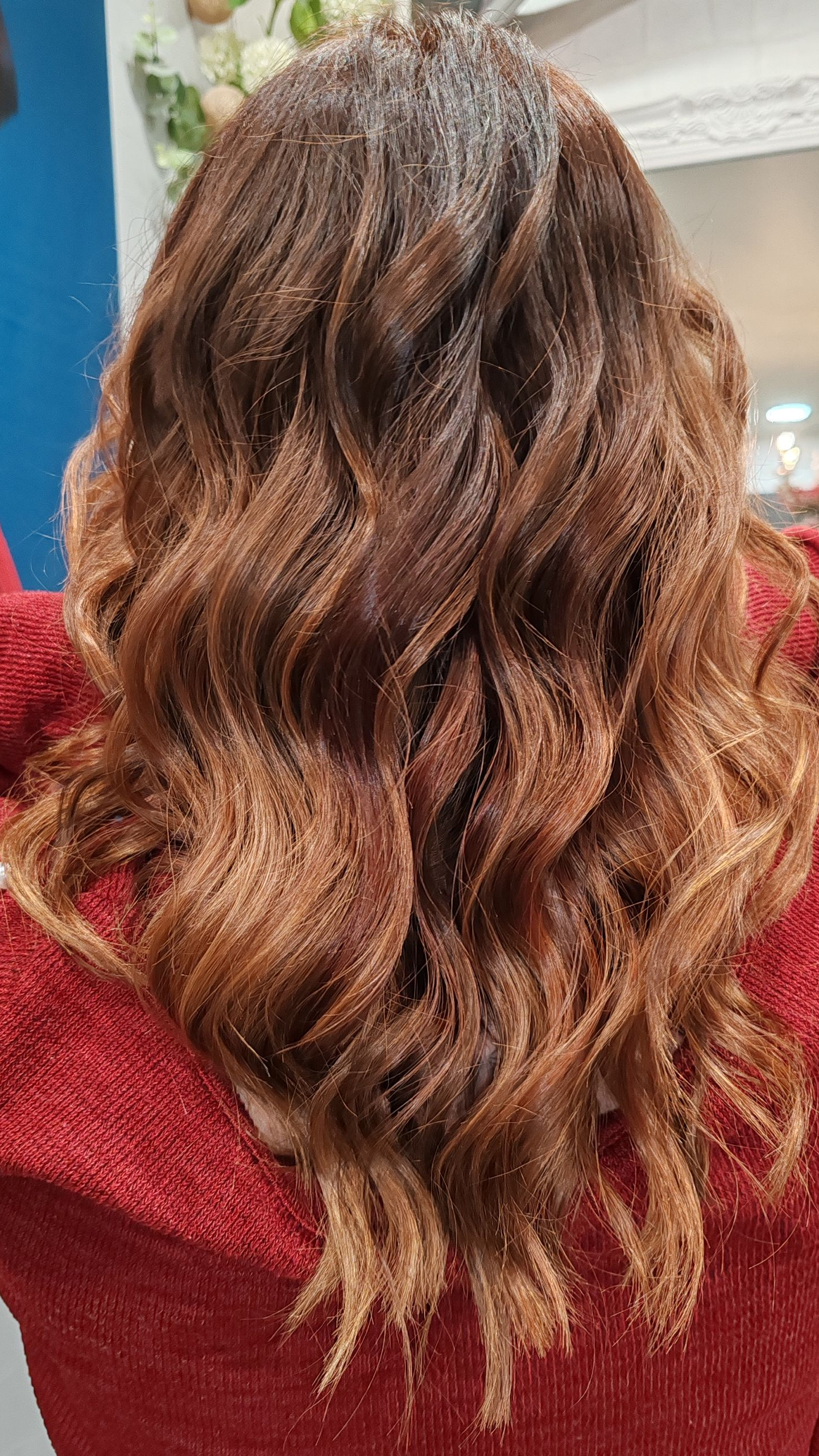Femme aux cheveux bruns ondulés coiffés avec des dégradés de couleurs.
