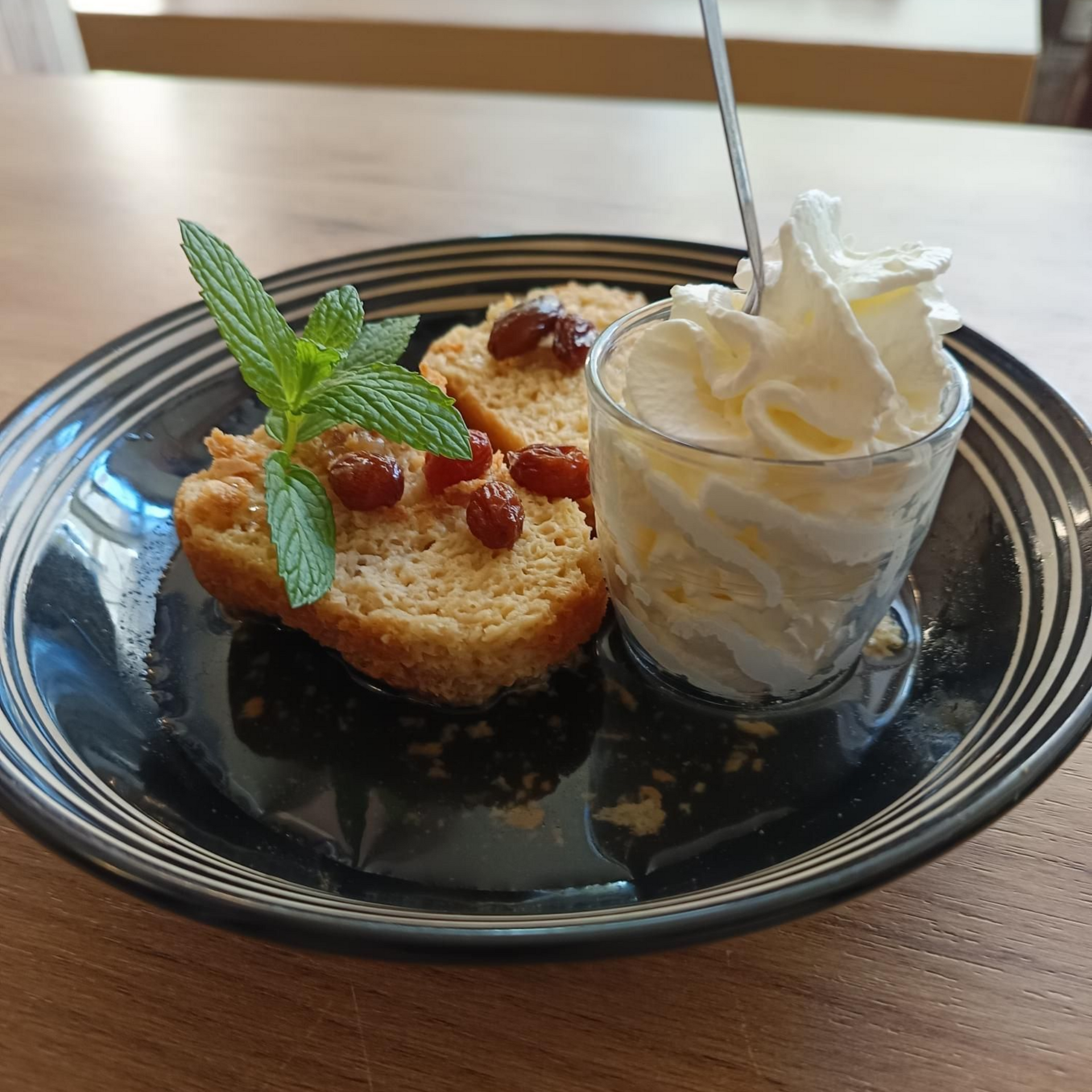 Un baba au rhum un petit pot de crème chantilly.