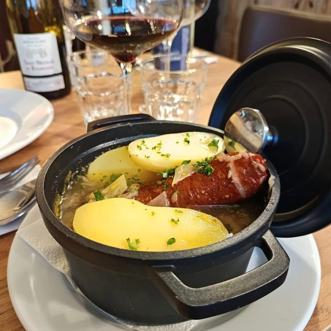 Un plat mijoté avec des pommes de terre vapeur et une saucisse fumée.