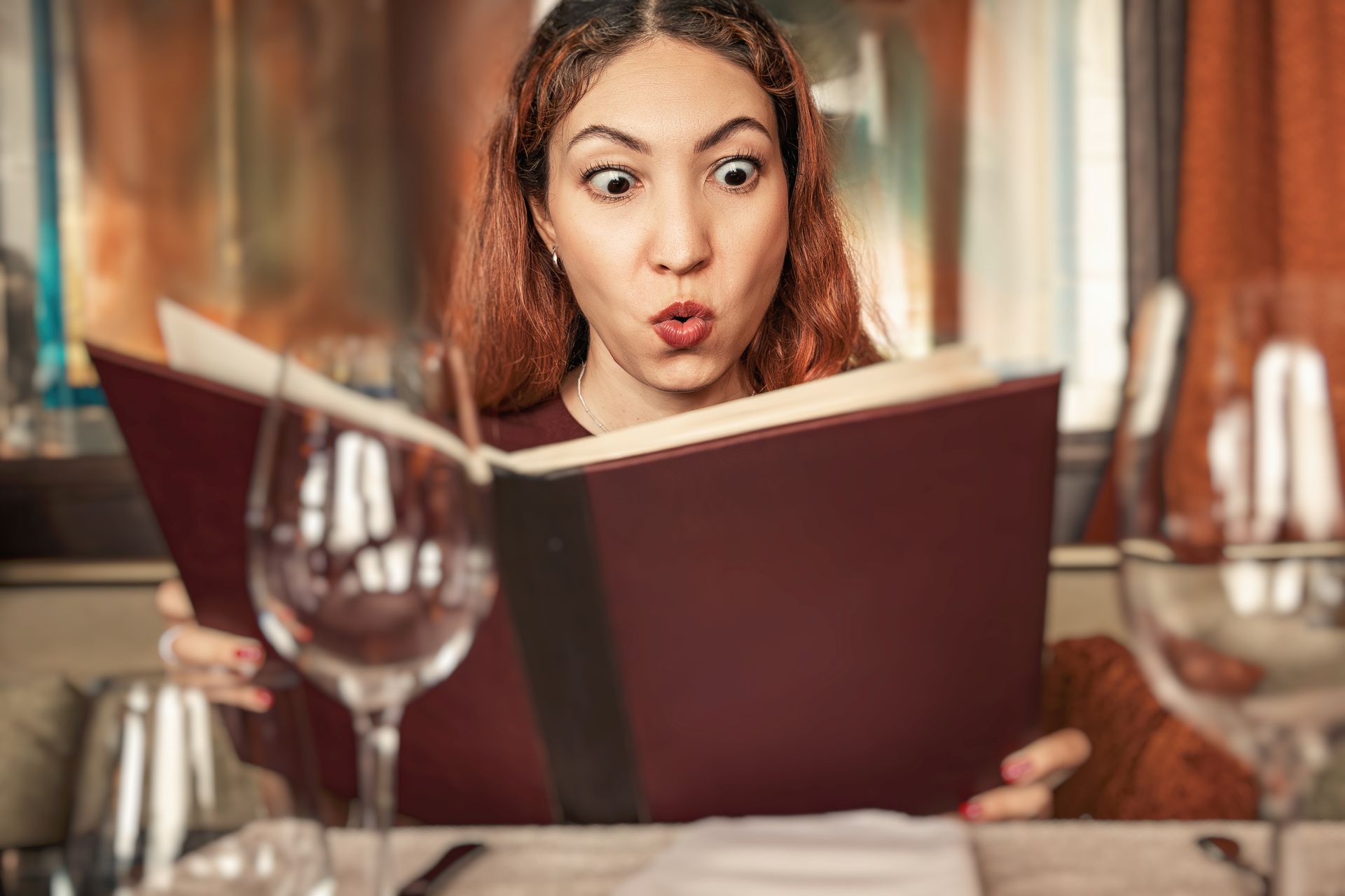 Une personne à l'air surpris qui regarde la carte d'un restaurant.