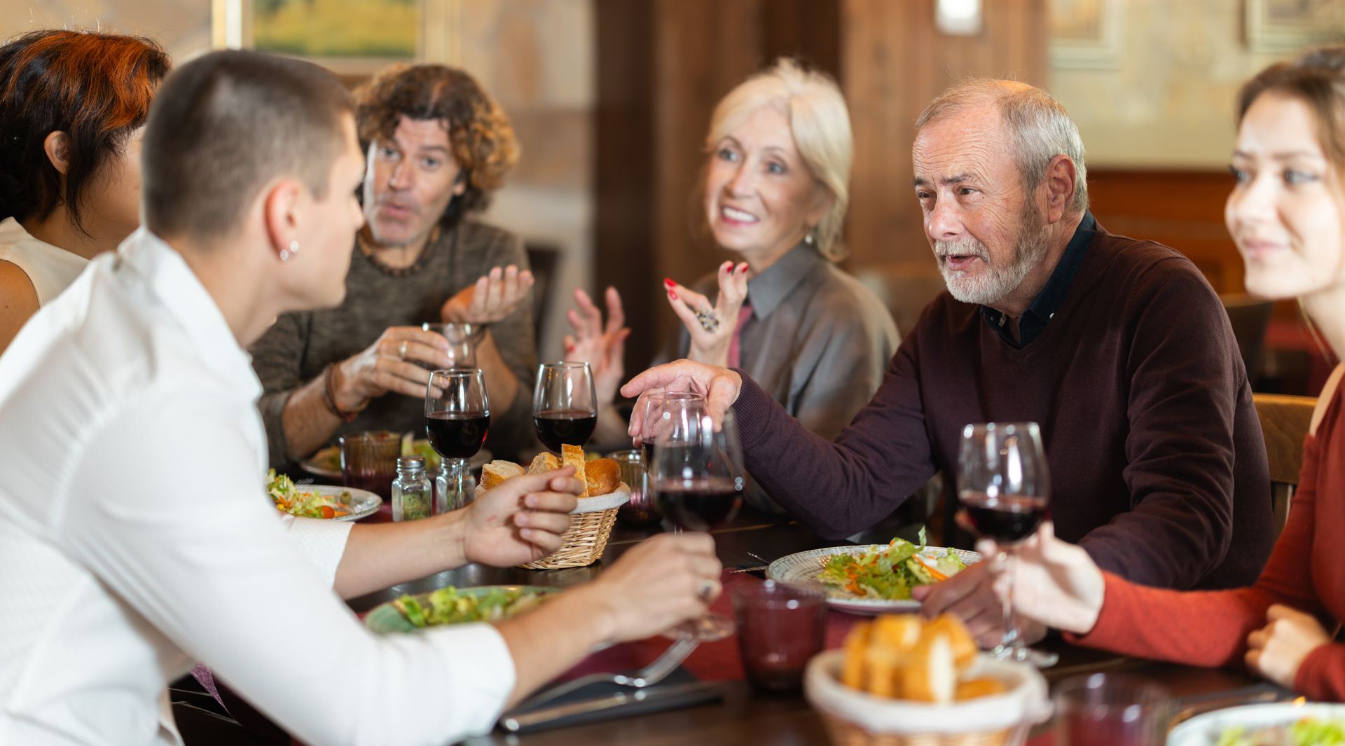 Des personnes qui mangent et qui discutent à la table d'un restaurant.