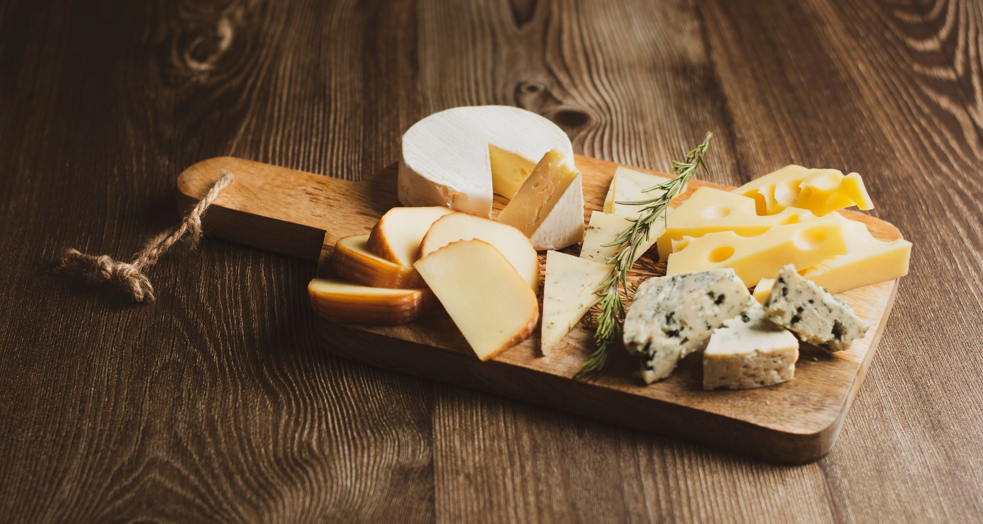 Une planche à découper avec diverses variétés de fromage.