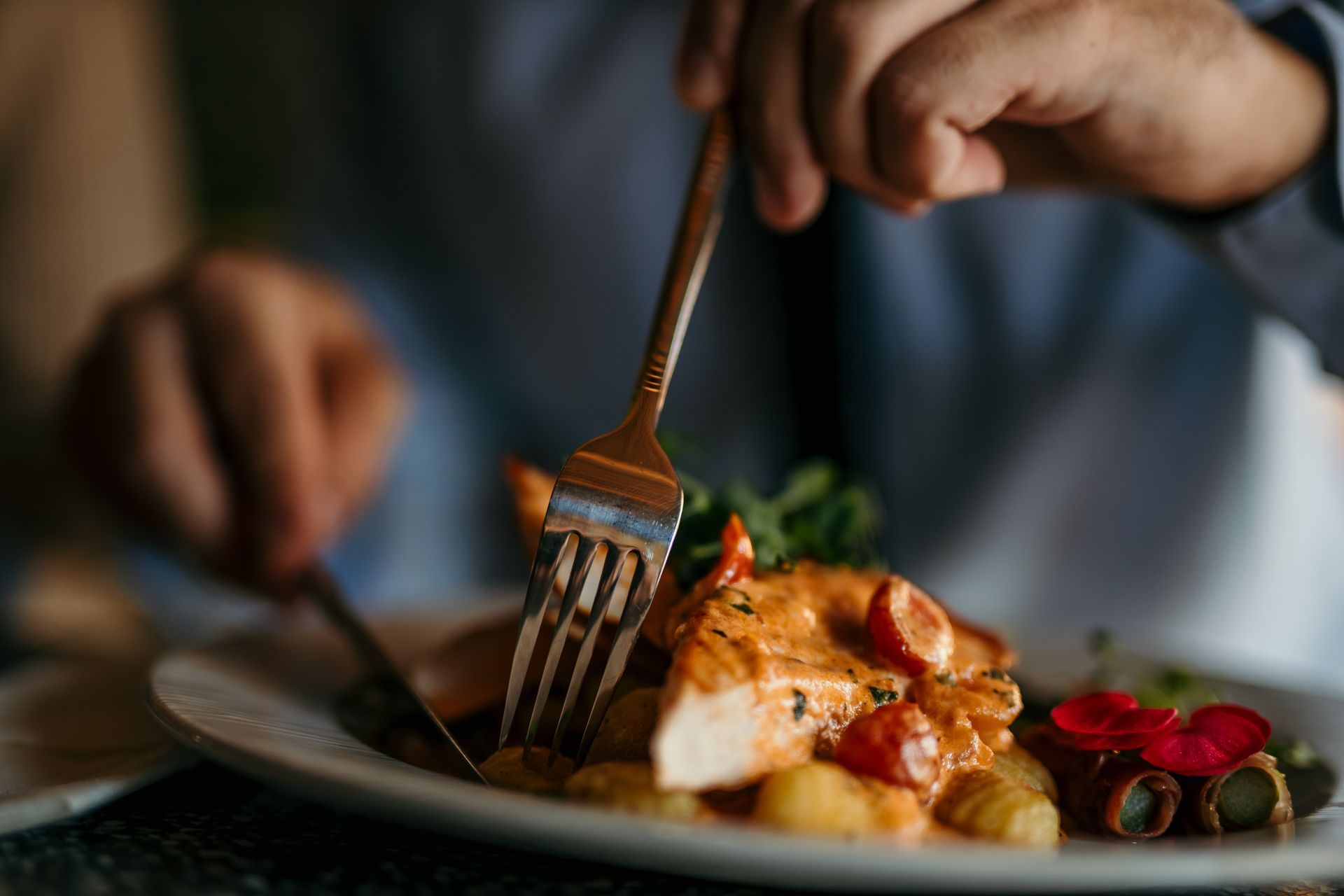 Gros plan sur une personne qui pique sa fourchette dans son assiette.
