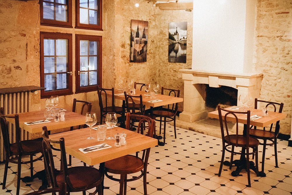 Intérieur du restaurant La Maison avec des tables et des chaises.