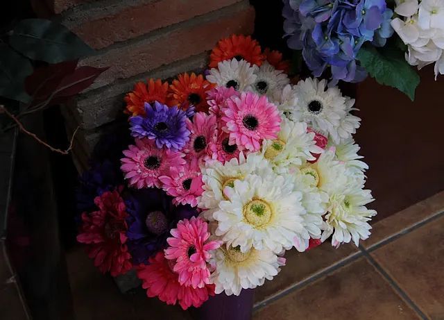 Un ramo de flores de colores se encuentra sobre un suelo de baldosas.