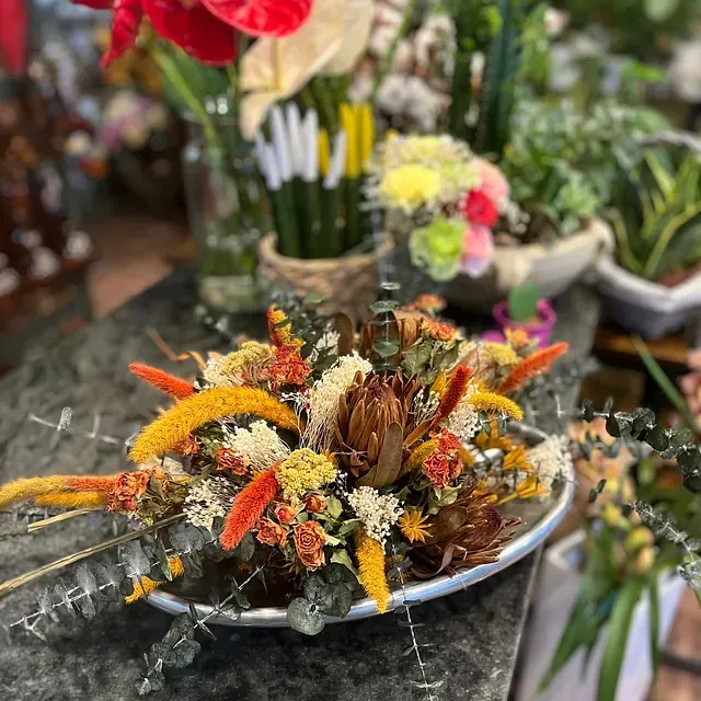 Un ramo de flores está en un plato sobre una mesa.
