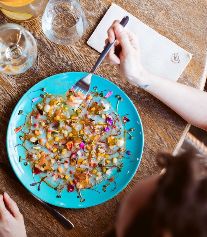 Una persona está comiendo un plato de comida con un tenedor.
