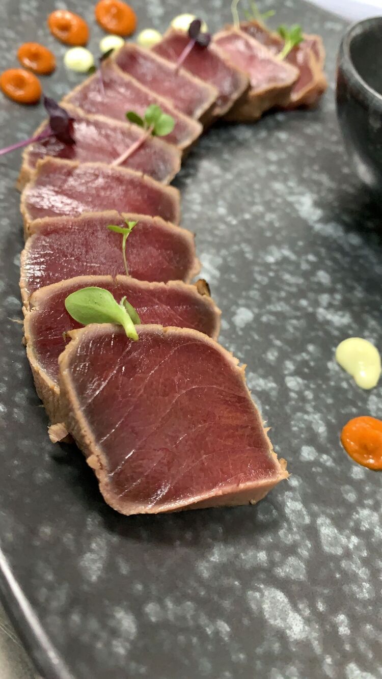 Un primer plano de un plato de comida con carne y verduras sobre una mesa.