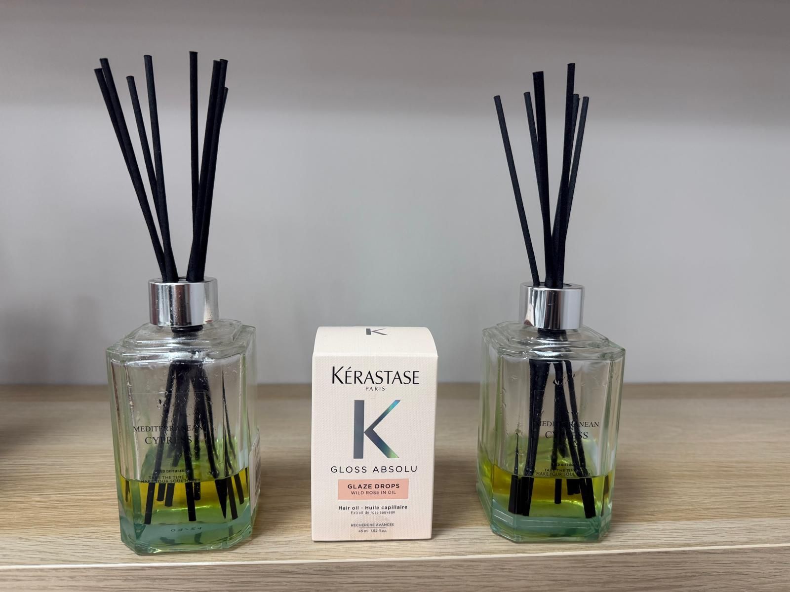 Vista posterior de una persona con cabello castaño largo y ondulado. Lleva una camiseta negra en un espacio interior.