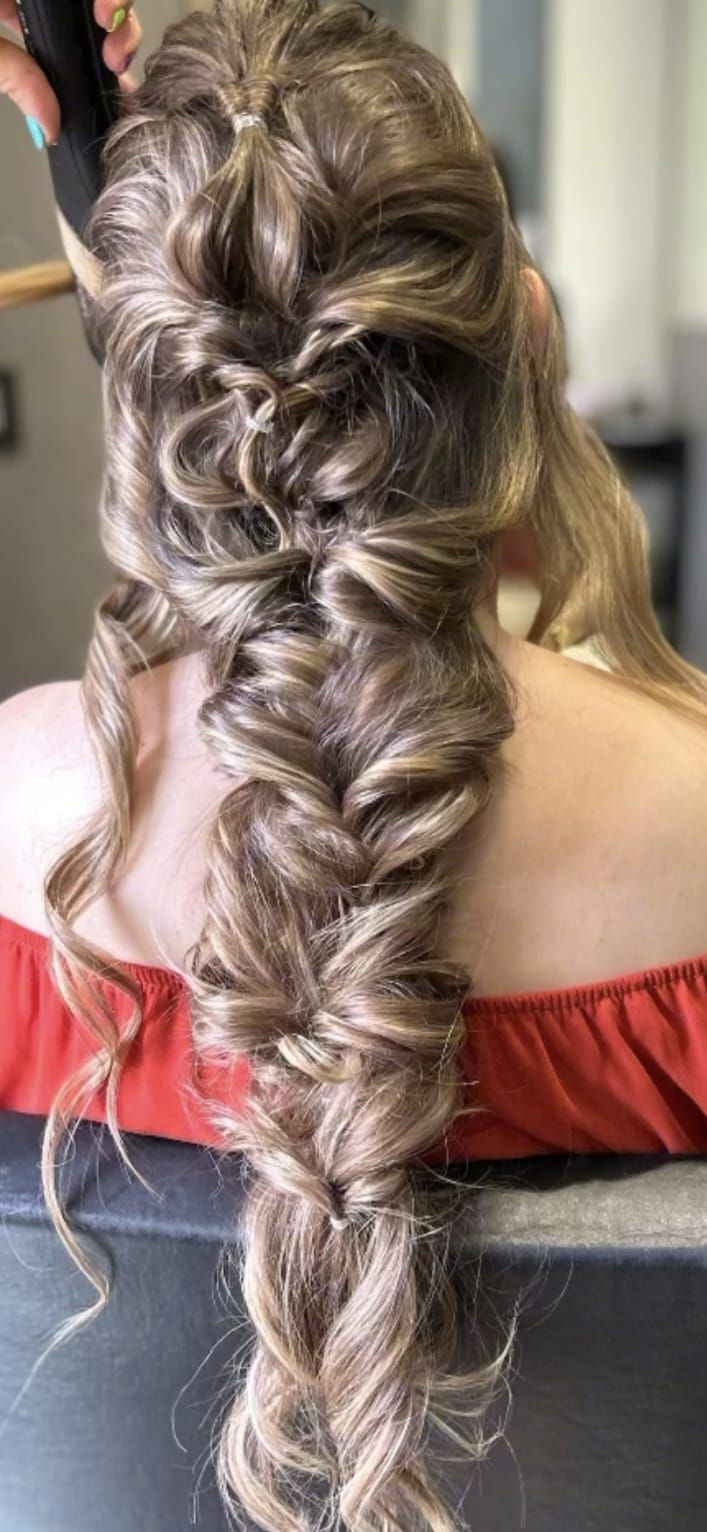Mujer con cabello castaño ondulado, peinado con un elegante recogido, vista de espaldas. 