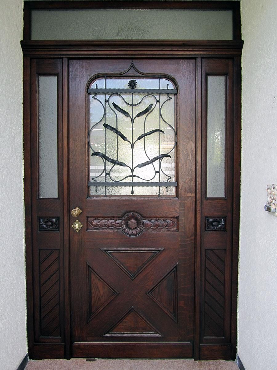 Eine Holztür mit einem Buntglasfenster